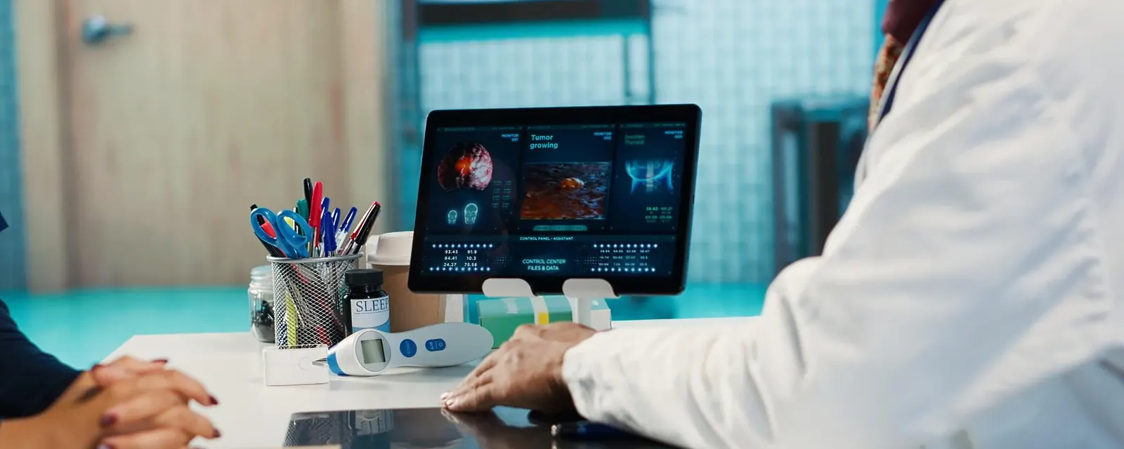 A clinician reviewing cardiac monitoring data on a consulting room screen