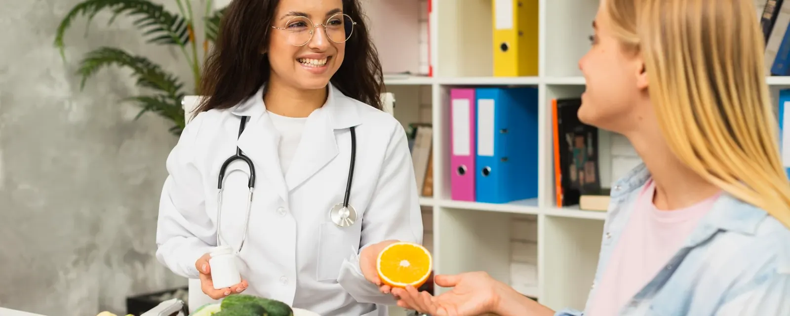 A dietitian discussing fresh vegetables and meal planning with a client