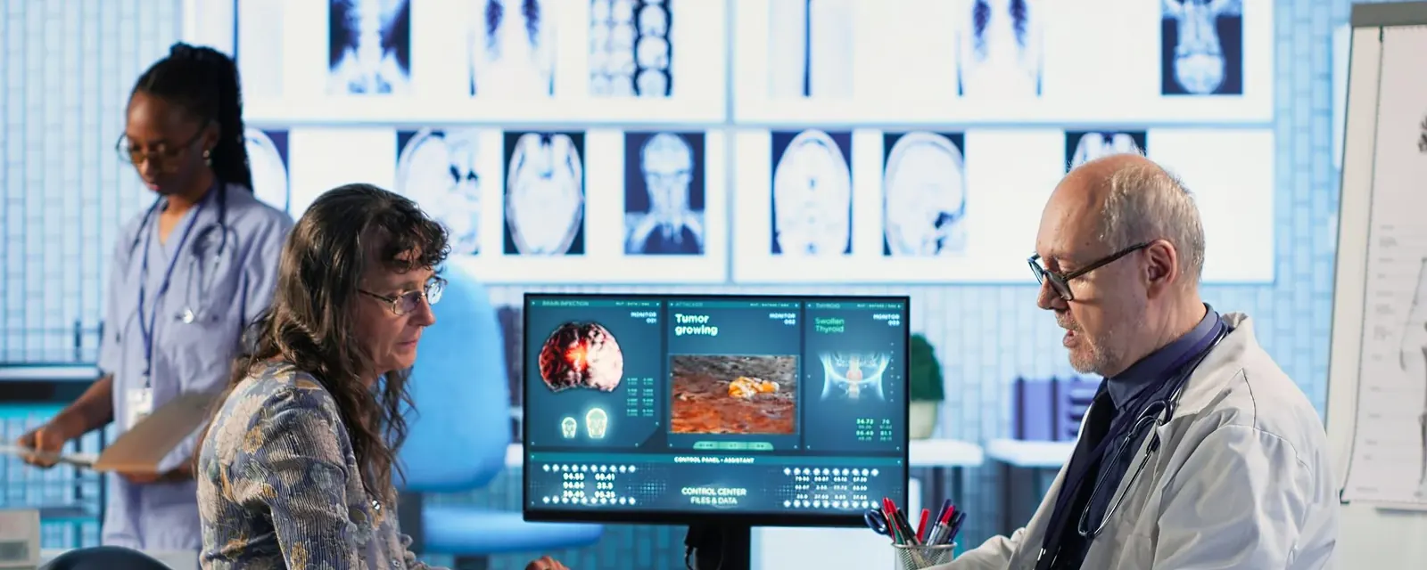 Clinicians reviewing diagnostic images on large reporting monitors